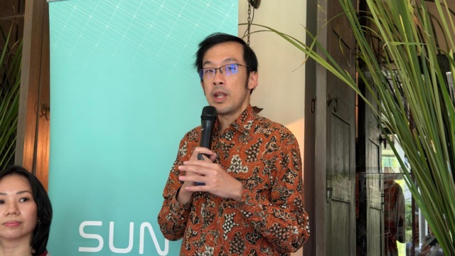 Jefferson Kuesar berbicara menggunakan mikrofon dalam Media Gathering SUN di Jakarta pada 15 Oktober 2026; identitas SUN terlihat pada latar acara.
