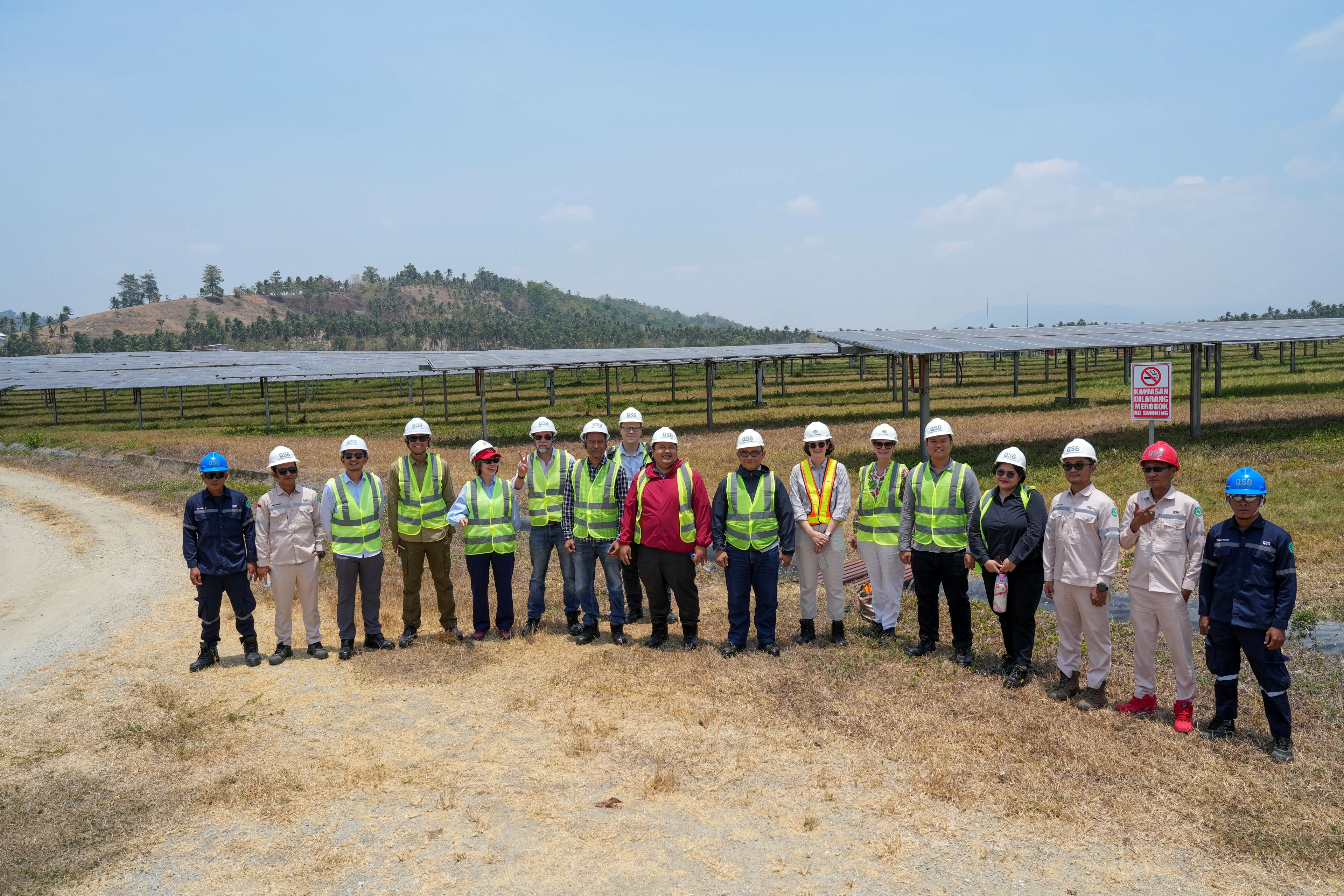 Peserta kunjungan di antara panel surya PLTS Gorontalo pada 22 September 2026. Identitas QSG terekam pada helm dan seragam. Foto dokumentasi asli KINETIK.